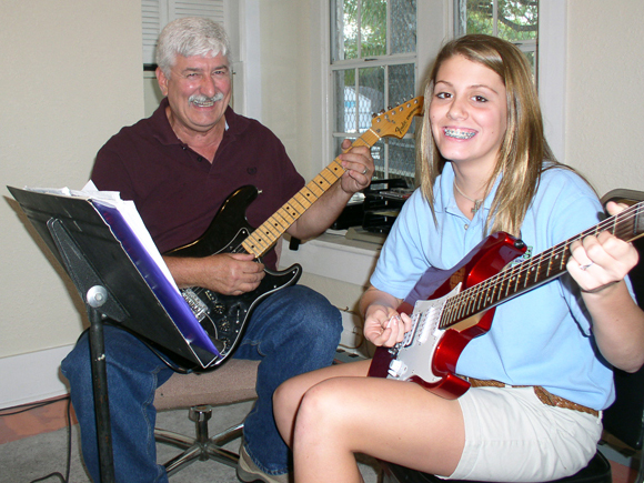 photo of george teaching a student the guitar